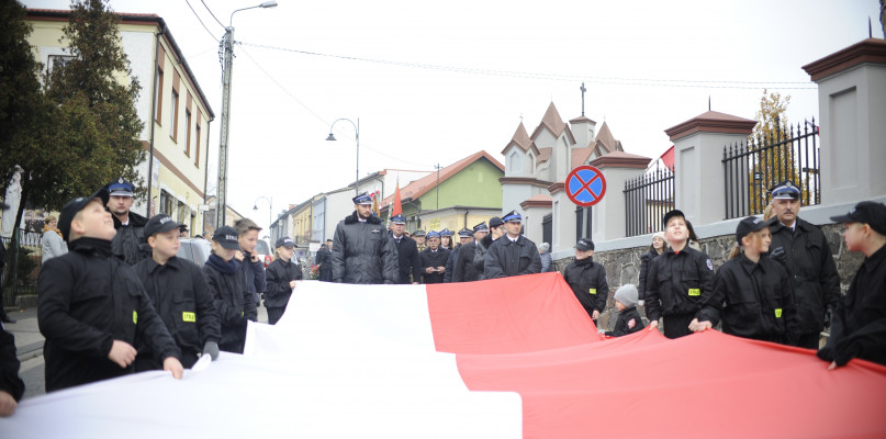 Druhowie z OSP w Lipnie podczas przemarszu nieśli wielką flagę Polski. /fot. Maciej Kamiński